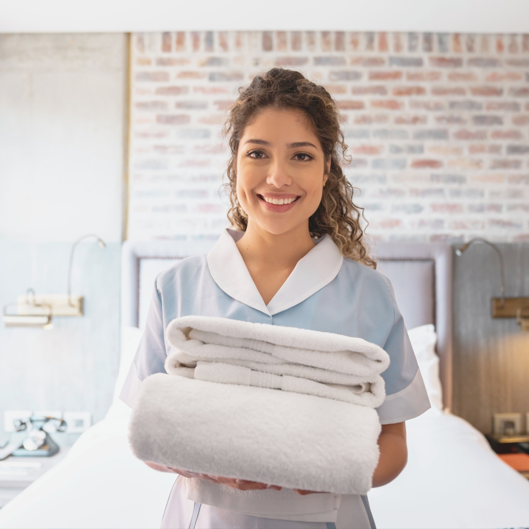 beautiful house maid holding cleaned towels